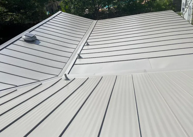 Solar attic fan installed on a metal roof for Roof Ventilation in Jericho